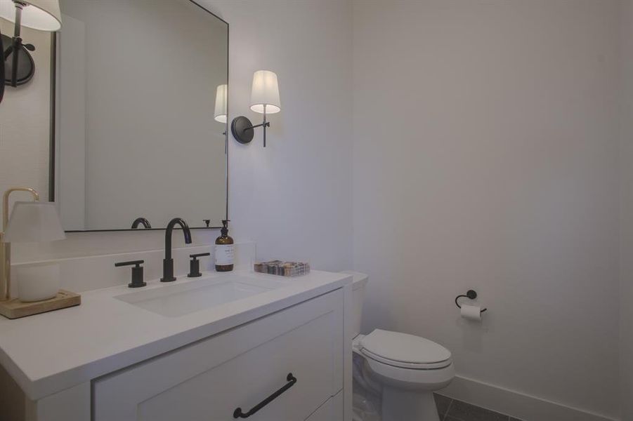 Bathroom featuring tile patterned floors, vanity, and toilet