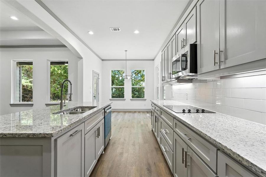 Kitchen with light stone counters, dark wood-style flooring, a kitchen island with sink, tasteful backsplash, and recessed lighting Kitchen with light stone counters, dark wood-style flooring, a kitchen island with sink, tasteful backsplash, and recessed lighting