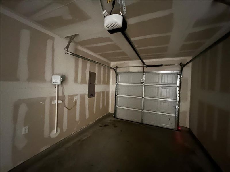 Single-vehicle garage with a sectional overhead door and an automatic opener system Single-vehicle garage with a sectional overhead door and an automatic opener system