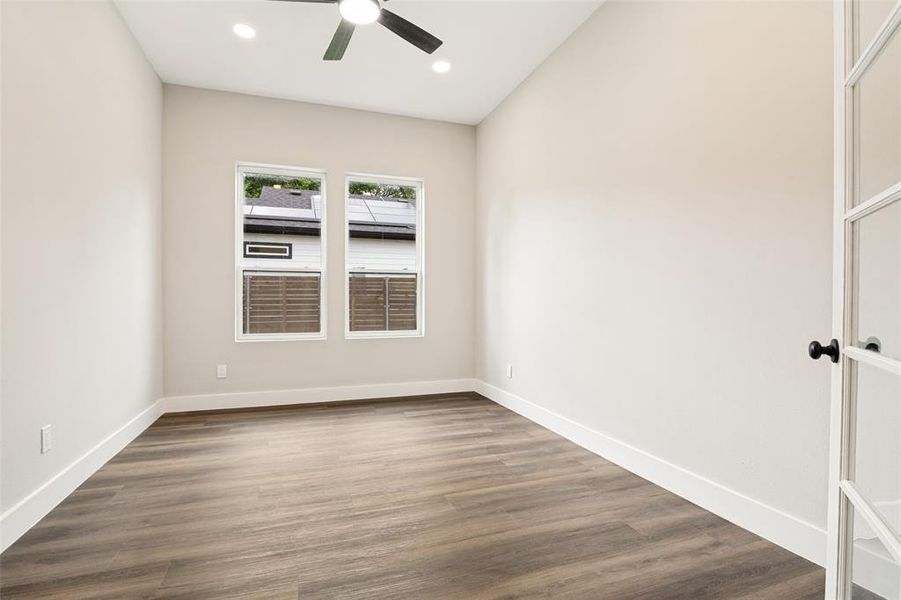 Spacious room featuring wood-finish flooring, recessed lighting, and a ceiling fan