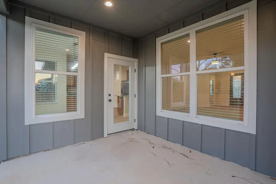 Entrance to property featuring board and batten siding and a patio area Entrance to property featuring board and batten siding and a patio area