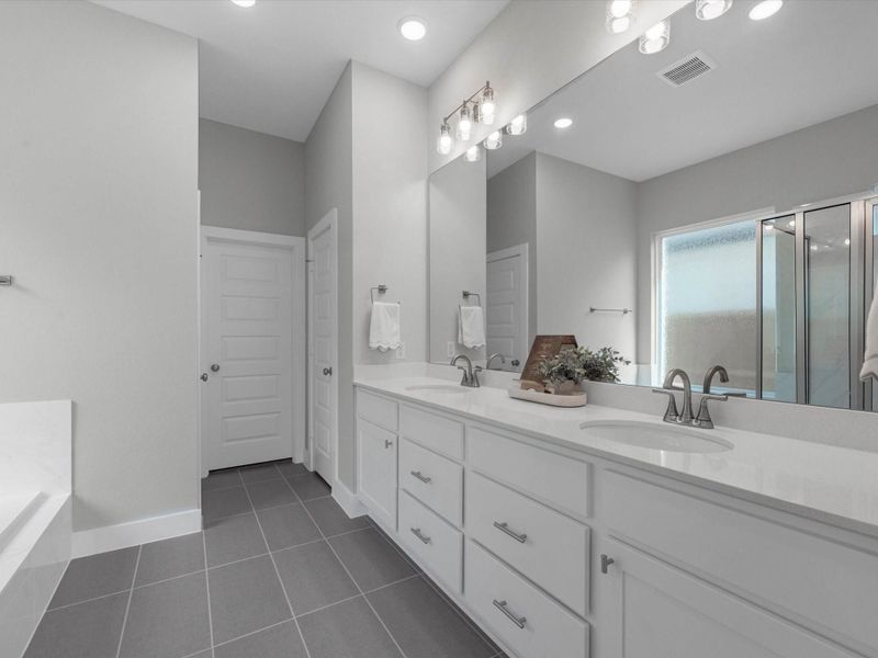 Primary bath with dual vanity, ample storage, and walk-in closet Primary bath with dual vanity, ample storage, and walk-in closet