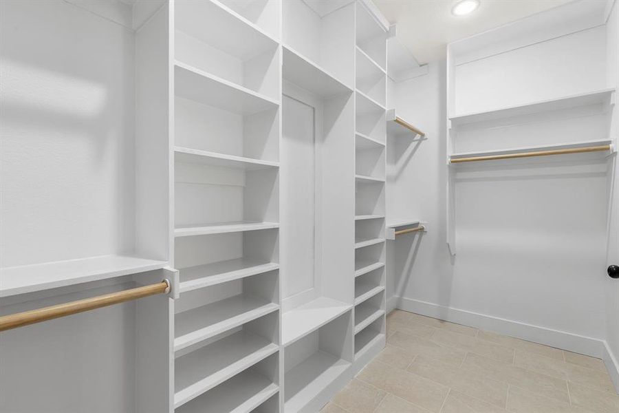 Walk in closet with light tile patterned floors