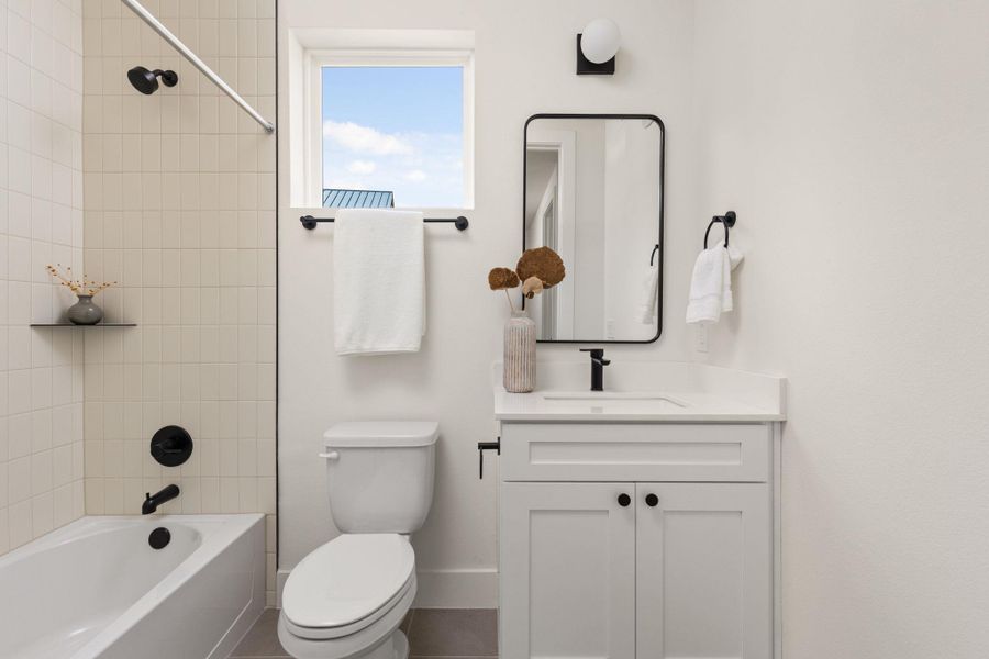 A well-lit bathroom showcases a clean white vanity and tiled shower for daily refreshment. A well-lit bathroom showcases a clean white vanity and tiled shower for daily refreshment.