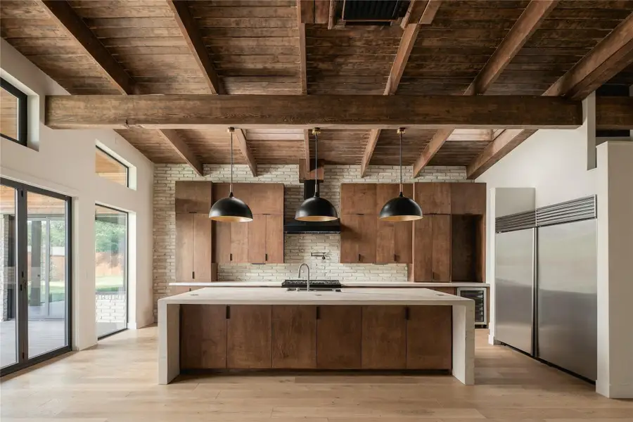 Expansive Kitchen with Site Poured Concrete Slab Countertop and Sub Zero Fridge + Z-Line Stove