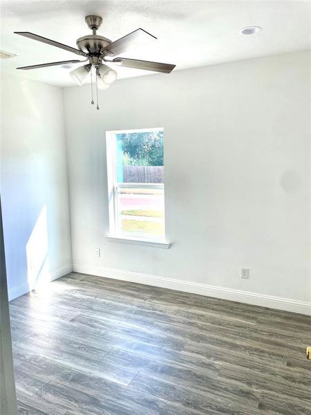 Unfurnished room featuring ceiling fan and dark hardwood / wood-style flooring