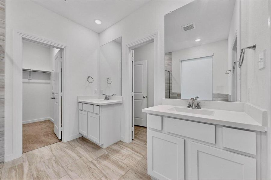 Full bath featuring two vanities, a spacious closet, and recessed lighting Full bath featuring two vanities, a spacious closet, and recessed lighting