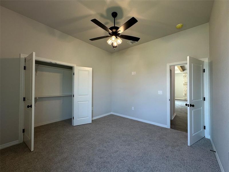 Unfurnished bedroom featuring carpet floors, a closet, and a ceiling fan Unfurnished bedroom featuring carpet floors, a closet, and a ceiling fan
