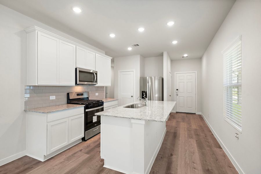 A kitchen with white cabinets.
