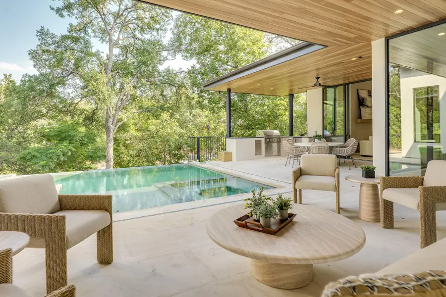 An inviting outdoor living space features a sparkling pool and a sophisticated al fresco dining area, perfect for entertaining. An inviting outdoor living space features a sparkling pool and a sophisticated al fresco dining area, perfect for entertaining.