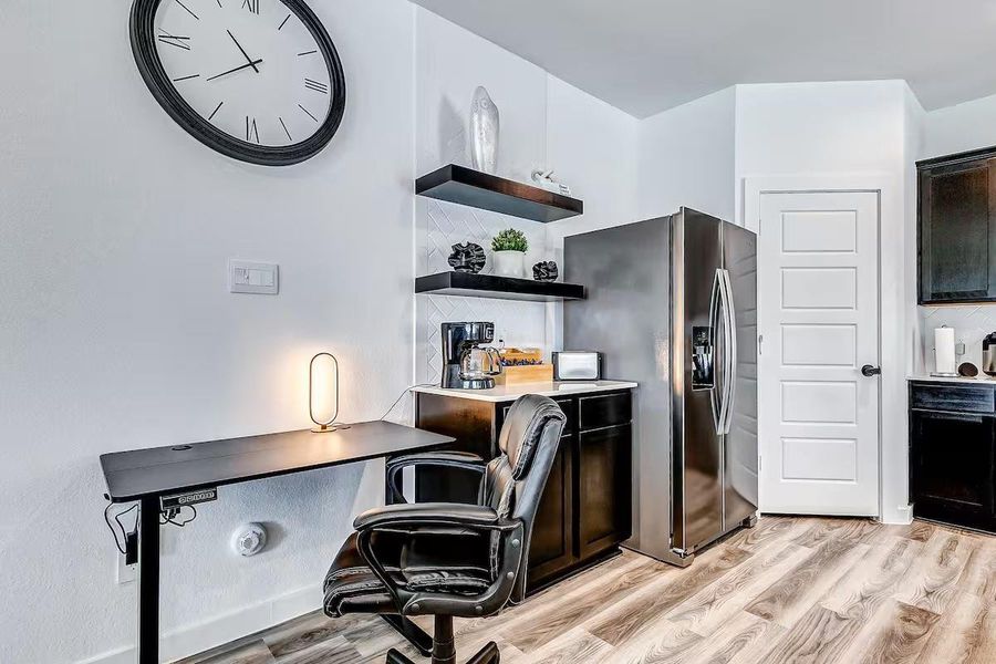An open, versatile workspace conveniently located next to the kitchen, perfect for a home office, study area, or everyday tasks.