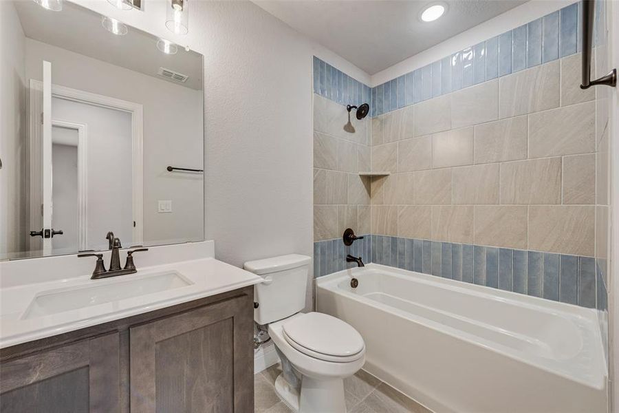 Full bath featuring shower / tub combination, vanity, and light tile patterned floors Full bath featuring shower / tub combination, vanity, and light tile patterned floors