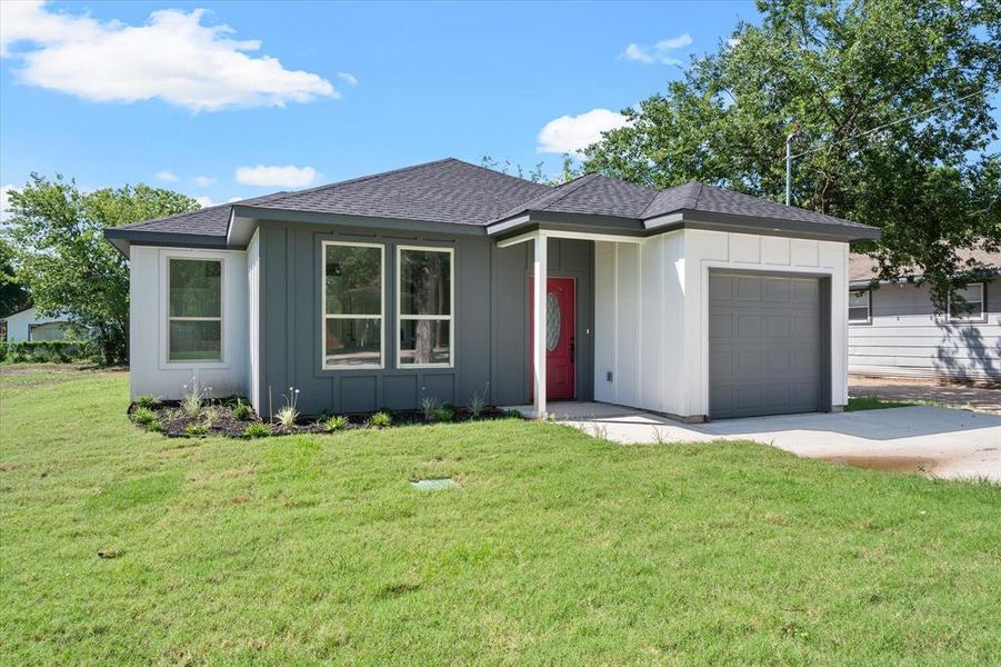 Ranch-style home with a garage and a front lawn