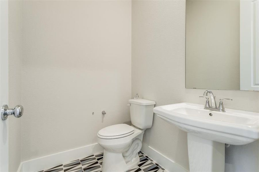 Bathroom with tile patterned floors, sink, and toilet