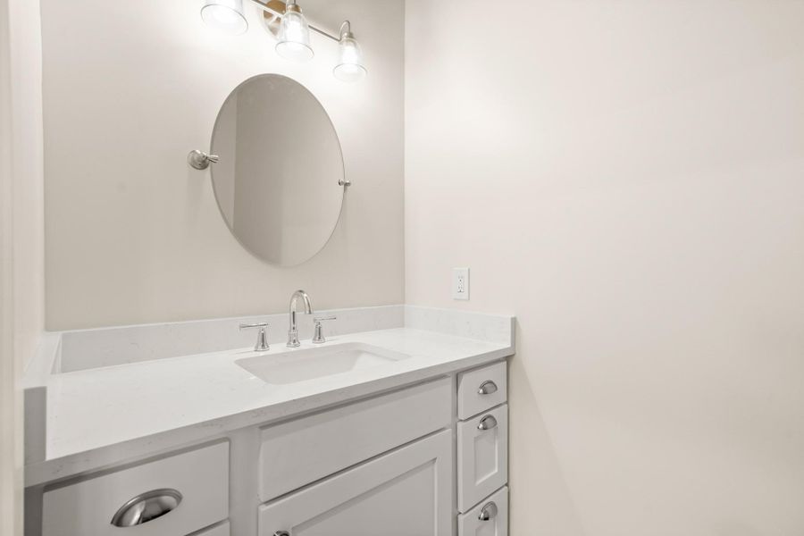 A well-appointed bathroom vanity with a clean white countertop and classic hardware. A well-appointed bathroom vanity with a clean white countertop and classic hardware.