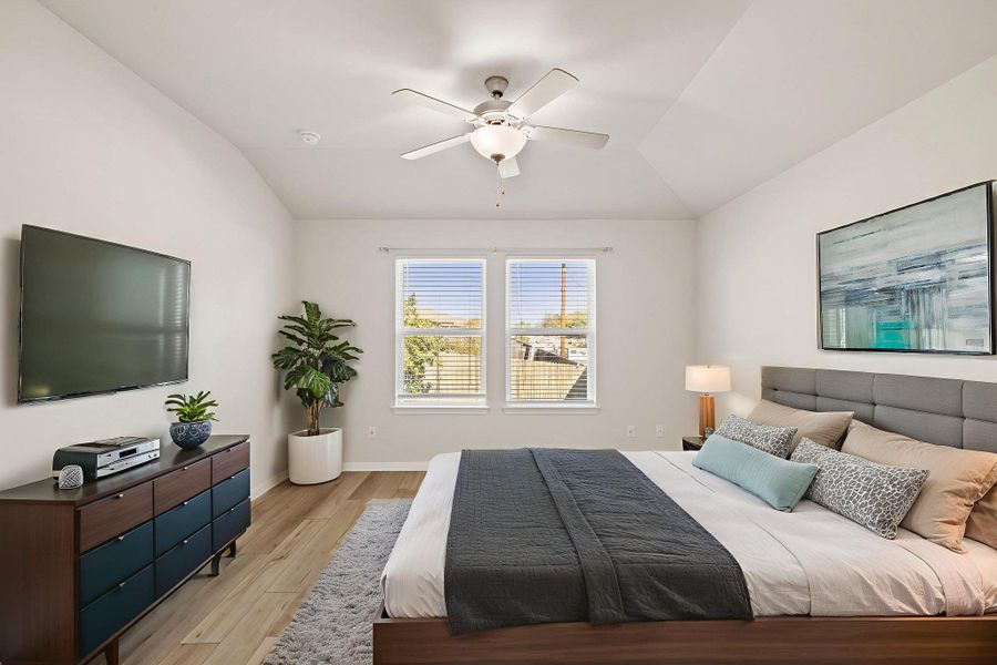 Bedroom with lofted ceiling, a ceiling fan, and wood finished floors Bedroom with lofted ceiling, a ceiling fan, and wood finished floors