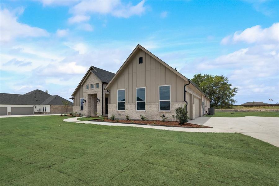 View of front facade featuring a front lawn and a garage