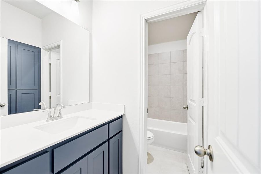 Bathroom with vanity, light tile patterned floors, and tub / shower combination