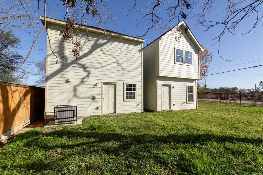 This room features neutral walls, carpeted flooring, and a ceiling fan with lights. It has large windows providing natural light and a view of the outdoors. A white door leads to another area of the home. This room features neutral walls, carpeted flooring, and a ceiling fan with lights. It has large windows providing natural light and a view of the outdoors. A white door leads to another area of the home.