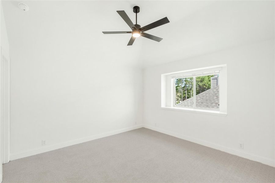 Empty bedroom with vaulted ceiling, ceiling fan, carpet flooring, and single window