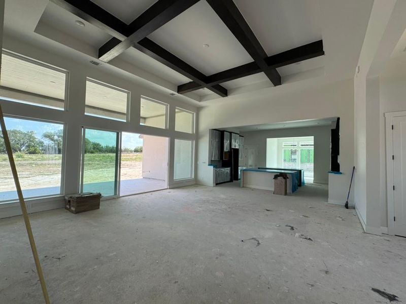 Unfurnished living room featuring coffered ceiling and beamed ceiling