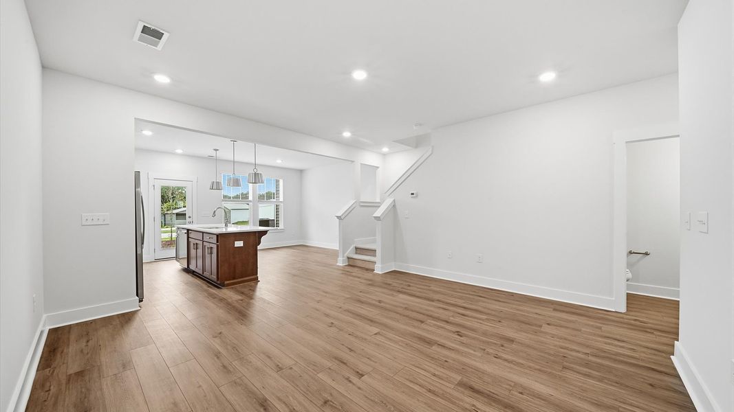 Spacious family room with rich hardwood flooring and elegant trim work in a reputable DRB Homes build Spacious family room with rich hardwood flooring and elegant trim work in a reputable DRB Homes build