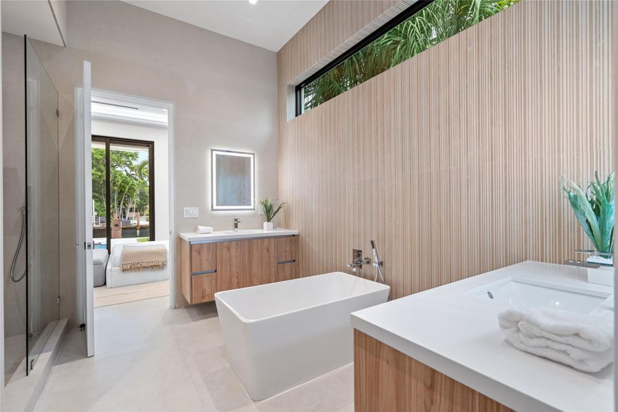 Elegant guest suite bathroom with floating vanities, freestanding soaking tub, and sleek modern finishes. Elegant guest suite bathroom with floating vanities, freestanding soaking tub, and sleek modern finishes.