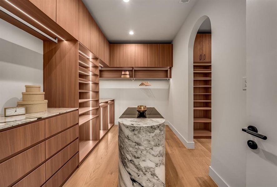 Walk in closet with light wood-style flooring Walk in closet with light wood-style flooring