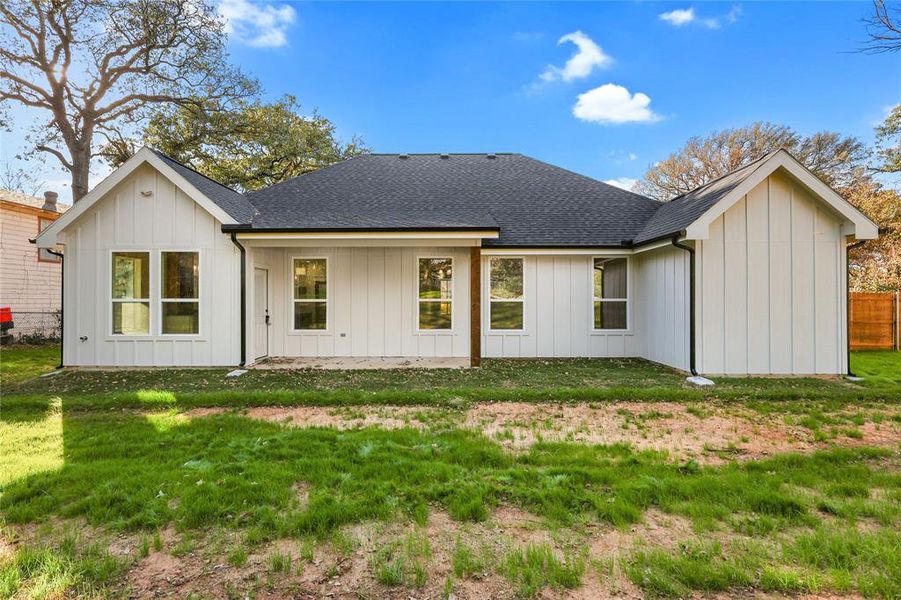 Rear view of house featuring board and batten siding and a shingled roof