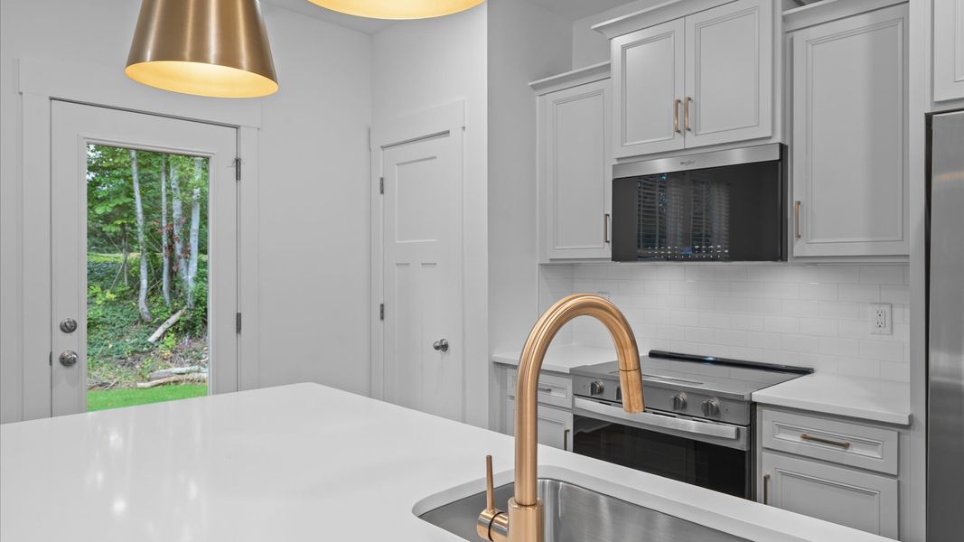 Superior kitchen with quartz countertops, pendant lighting, and a generously sized island Superior kitchen with quartz countertops, pendant lighting, and a generously sized island