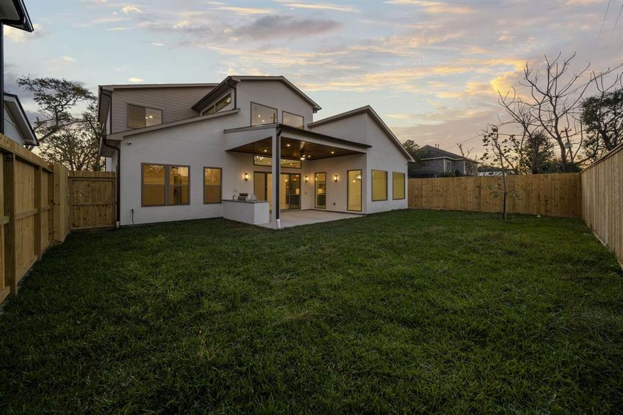 This spacious backyard offers the perfect balance of room for pets to play freely while keeping maintenance time to a minimum. The covered patio with an outdoor kitchen enhances the functionality of this outdoor space, making it ideal for relaxing or entertaining. Fully fenced for privacy, this backyard provides a safe and versatile retreat for your family and furry friends.