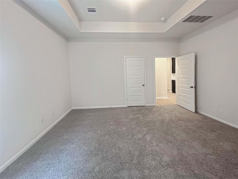 Owner's Suite with Tray Ceiling. Home under construction. Sample floor plan photo used for illustrative purposes only. Upgrades, selections options, windows and colors may vary.