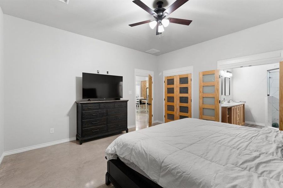 Master bedroom with large walk in closet with decorative wooden doors.