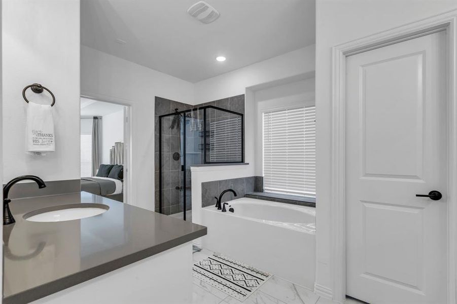 Bathroom featuring plus walk in shower, a healthy amount of sunlight, vanity, and tile patterned floors