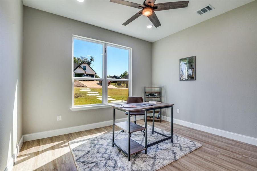 Office area with light wood-type flooring, recessed lighting, and a ceiling fan