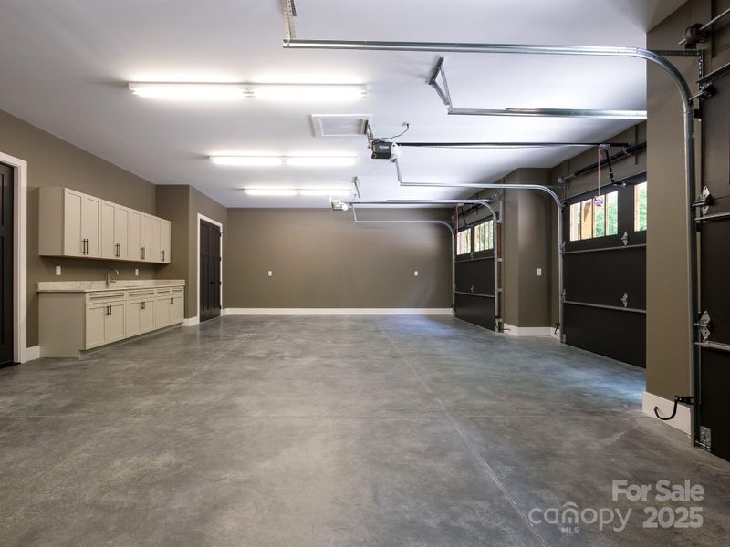 Oversized three car garage with built in cabinetry/sink.
