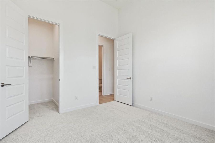 Unfurnished bedroom featuring light colored carpet and a closet