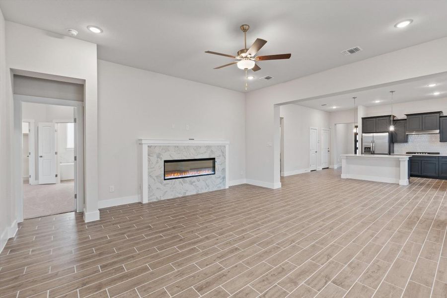 An inviting open-concept living area features elegant tile flooring and a sleek fireplace. An inviting open-concept living area features elegant tile flooring and a sleek fireplace.