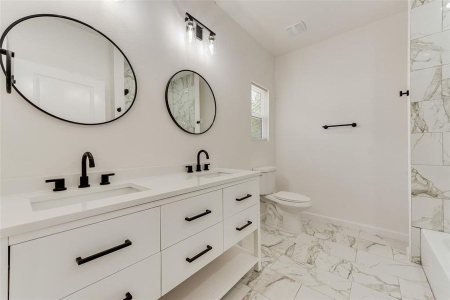 Bathroom with vanity, toilet, and a bath