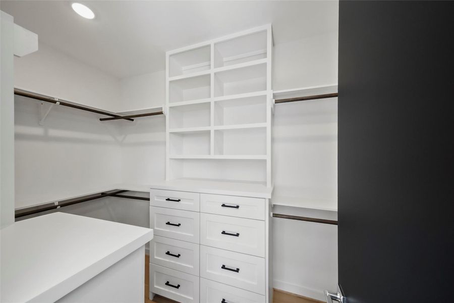 Spacious master closet with elegant custom shelving for optimal organization. Spacious master closet with elegant custom shelving for optimal organization.