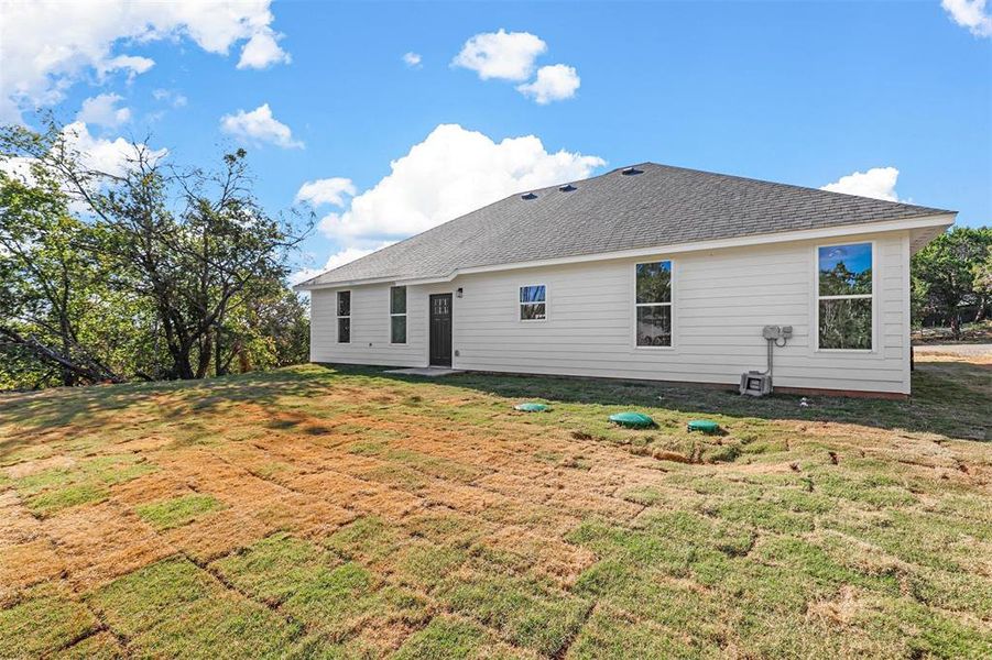 Back of house with a lawn