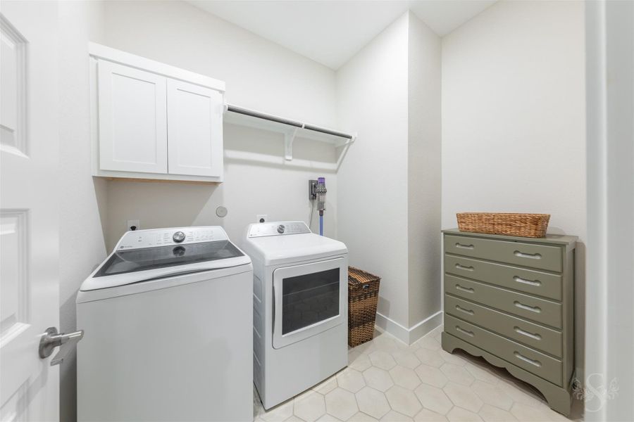 Spacious utility room offers upper cabinetry, a hanging rod and ample room for additional storage. Modern hexagon tile flooring adds a stylish finishing touch. Spacious utility room offers upper cabinetry, a hanging rod and ample room for additional storage. Modern hexagon tile flooring adds a stylish finishing touch.