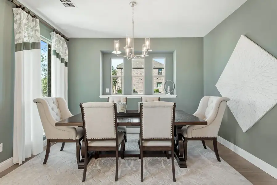 Formal dining room with dark wood table, six upholstered chairs, and a chandelier overhead