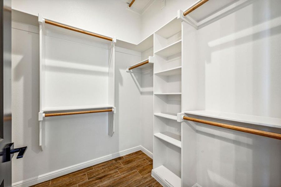 Spacious closet with dark wood-type flooring