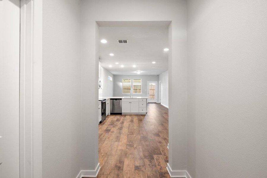Hall featuring dark wood-type flooring and recessed lighting