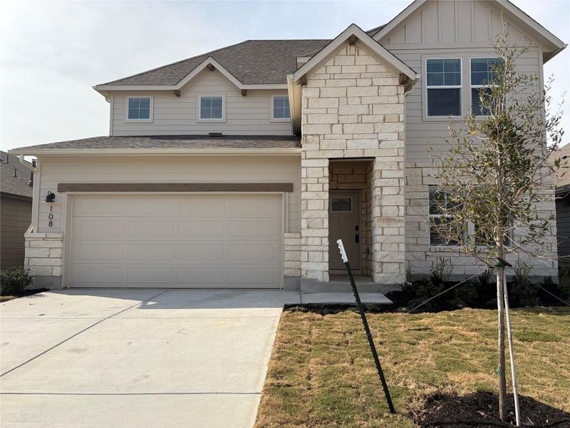 View of front of property with board and batten siding, stone siding, concrete driveway, a shingled roof, and an attached garage
