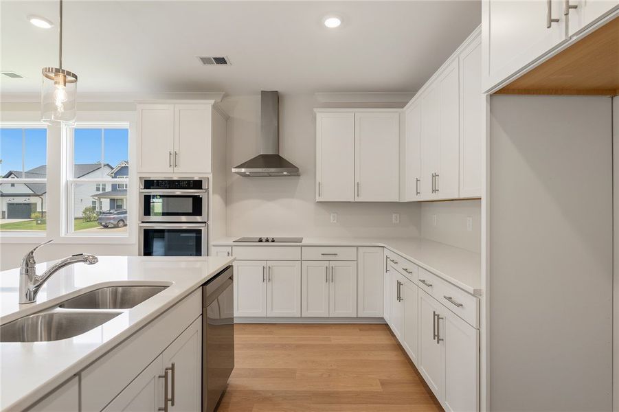 A well-lit kitchen with sleek white cabinetry, a l