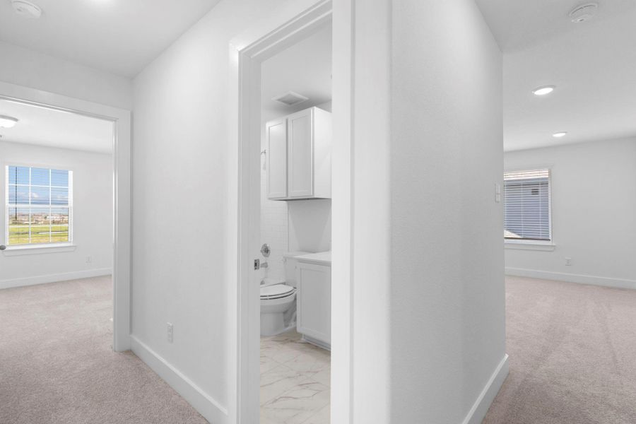 Hallway leading to an additional bedroom and full bath for added privacy.