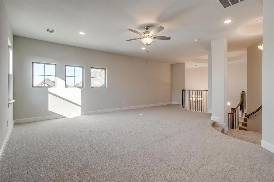 Carpeted empty room featuring ceiling fan