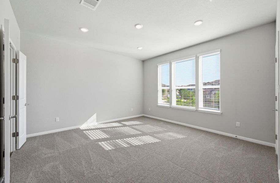 Spacious room with plush gray carpeting, three large windows with horizontal blinds, and recessed lighting Spacious room with plush gray carpeting, three large windows with horizontal blinds, and recessed lighting